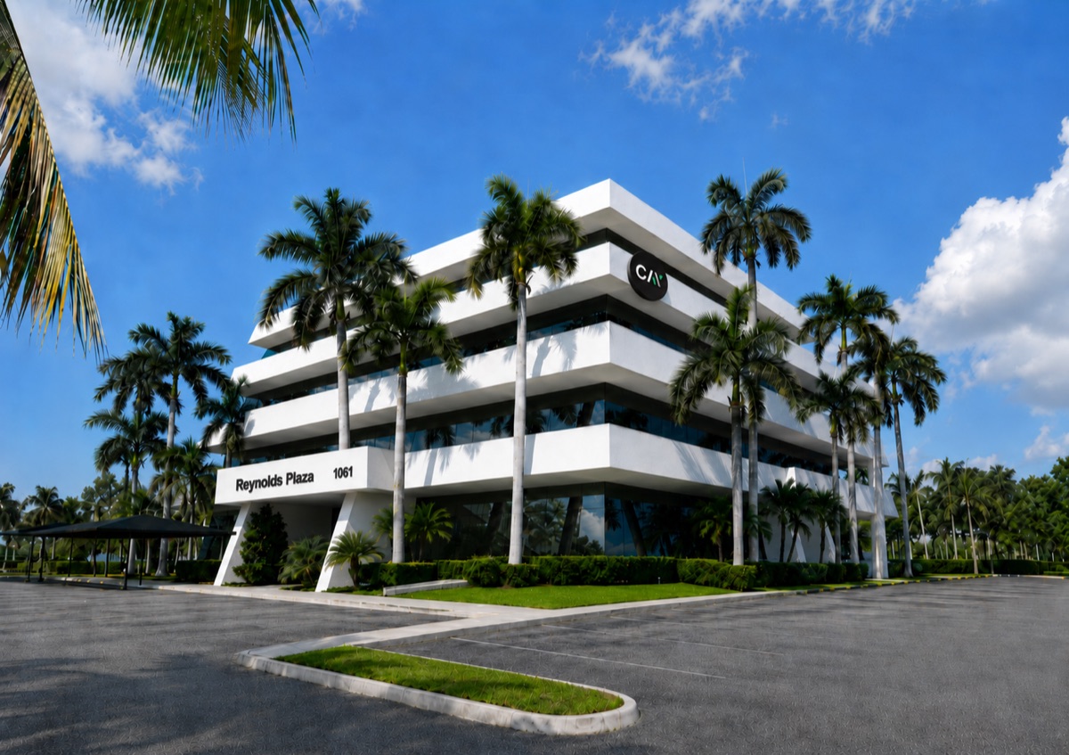 Cay Digital's office at Reynolds Plaza in Jupiter, Florida — a white modern building framed by palm trees